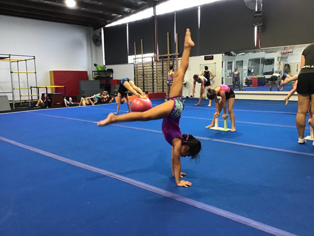 gymnast entering handstand shape on gymnastics floor