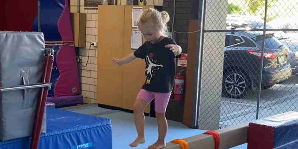 Young girl practicing on a balance beam