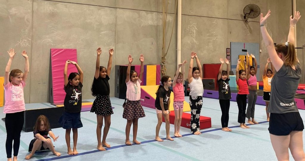 kids line up for a class with the coach in front.